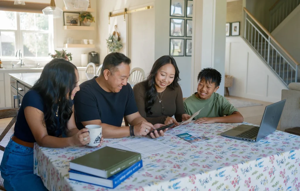 Four people discuss schoolwork and planning at a table.
