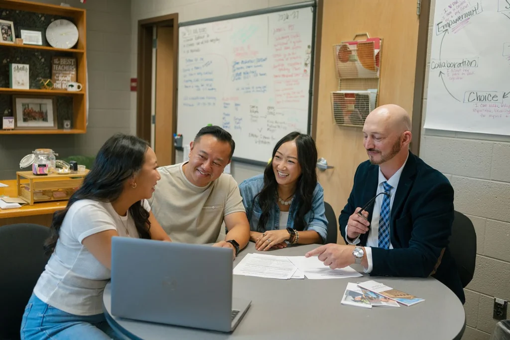 Students and adults compare planning materials with an adviser.