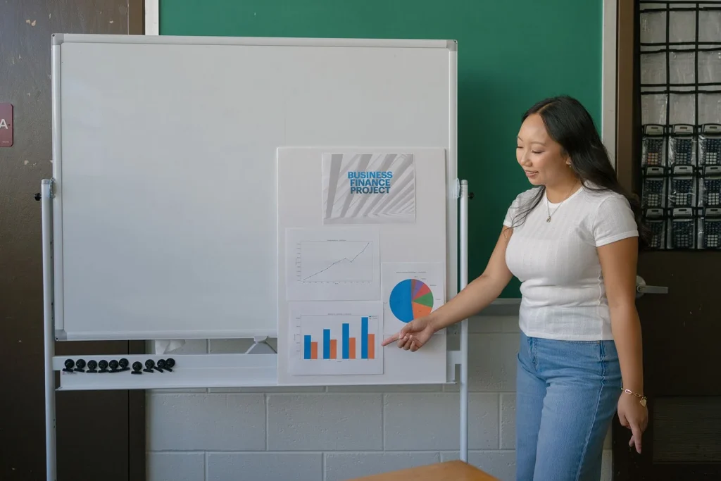A student presents information at a classroom board.