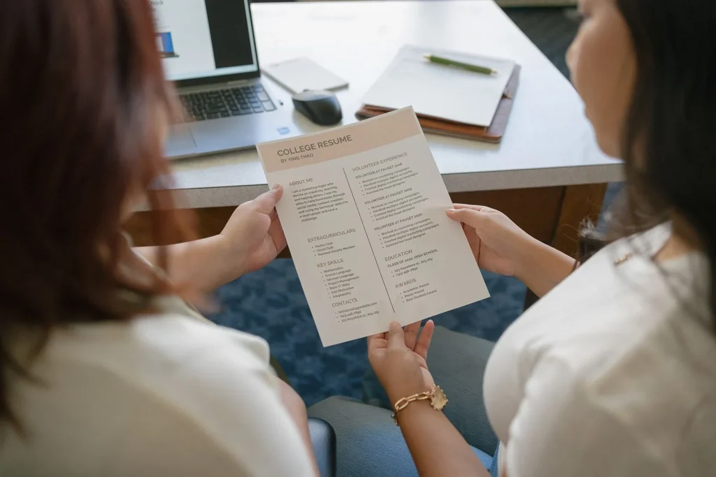 A student and a teacher review a written document.